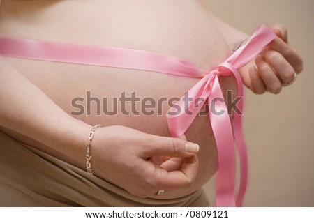 pink pregnant belly. stock photo : Pregnant belly with pink ribbon.