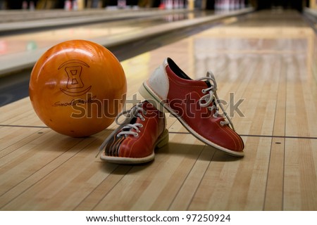 Bowling kit with shoes and ball on the alley
