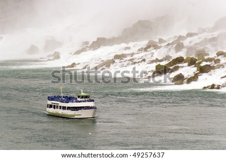 niagara falls and boat full of people on river in mist major canadian american landmark