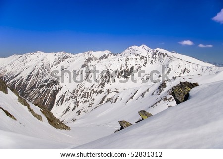 mountain valley in spring in fagaras carpathians in romania snow covering the rocks