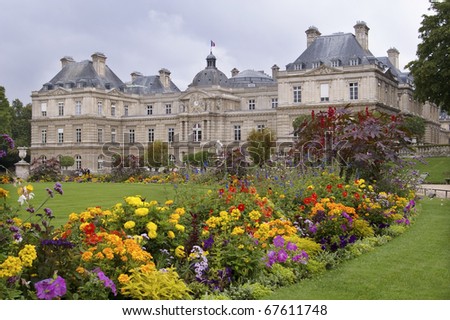 Luxembourg palace in the park in Paris with flowers lawn and alley in front