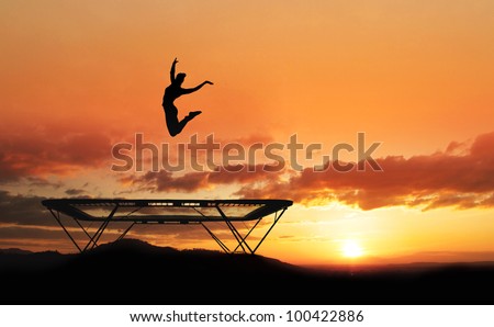 silhouette of girl jumping on trampoline in sunset