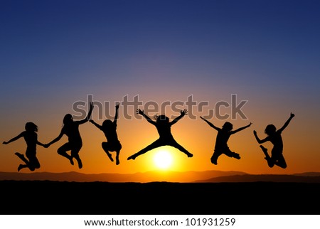 silhouette of kids jumping on beach in sunset