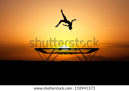 silhouette of female gymnast jumping on trampoline