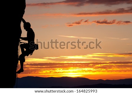 silhouette of climber on rock face