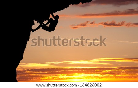 silhouette of climber on rock face