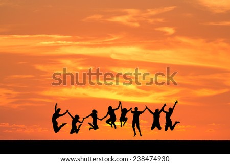 silhouetted friends jumping in sunset