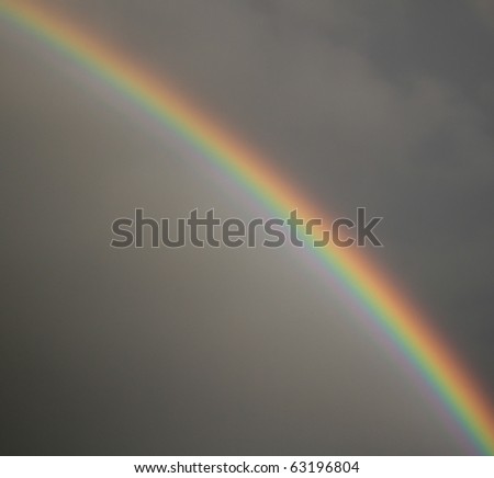 rainbow in front of dark cloud