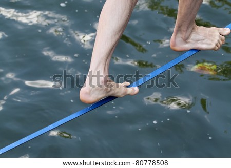 feet on slackline over water