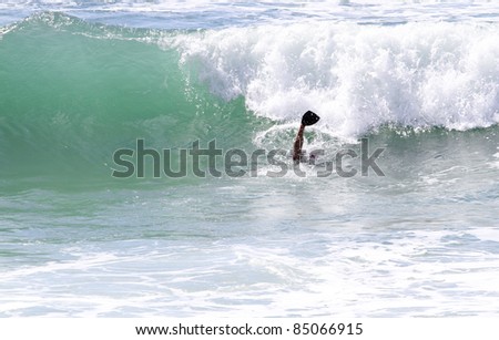 bodyboarder with fins doing duckdive under wave