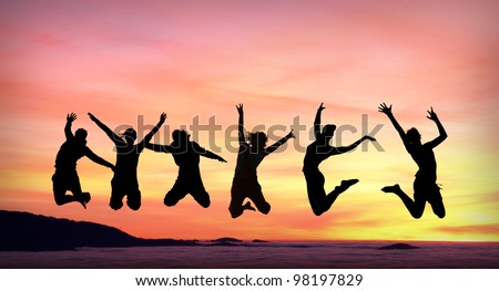 silhouette of female friends jumping in sunset