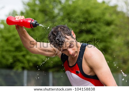 athlete is refreshing himself with water