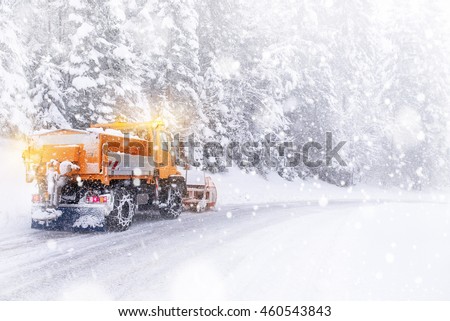 Snowplow cleared the snow-covered icy road