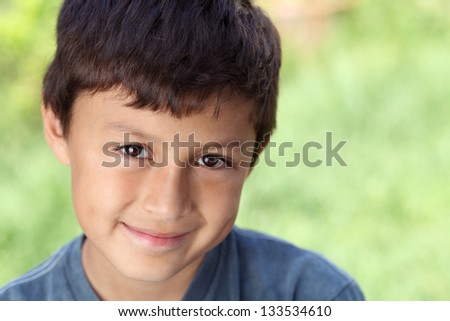 Smiling young boy outside with copy space to right