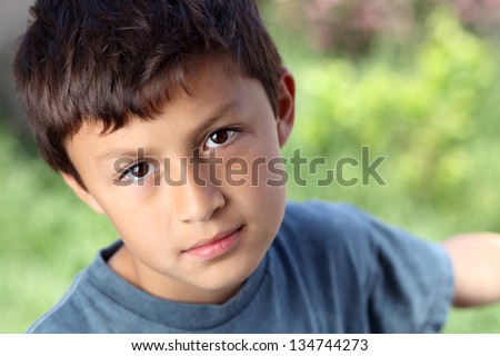 Serious young boy outside with copy space to right