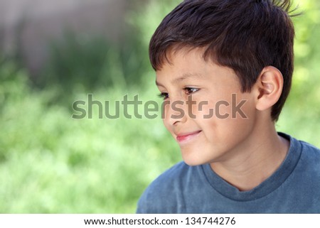 Smiling young boy outside with copy space to left