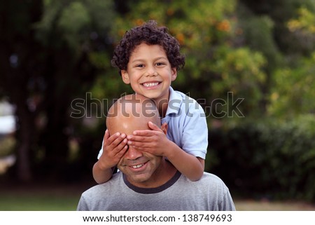 Mixed race father and son playing in the back garden