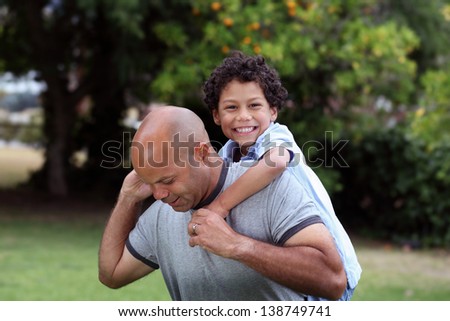 Mixed race father and son playing in the back garden