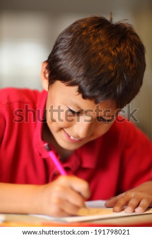 Young boy drawing for homework - with very shallow depth of field - portrait format