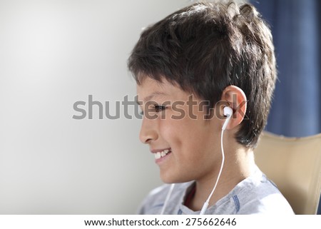 Smiling young boy in profile with earphones - shallow depth of field