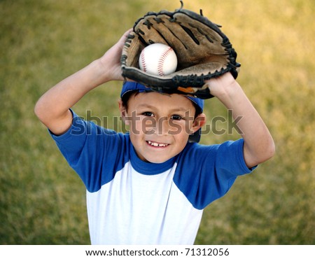 Authentic happy smiling young Latino boy dressed in blue baseball sleeves with cap, glove and ball