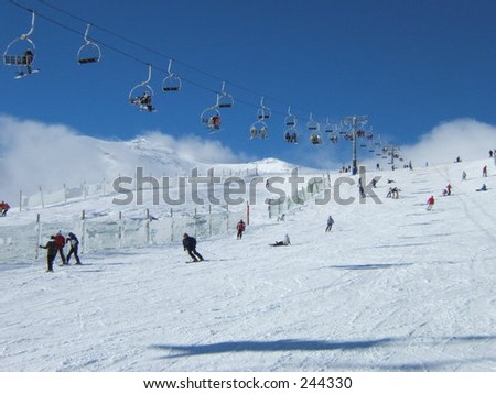 snow landscape with people skiing and a cableway