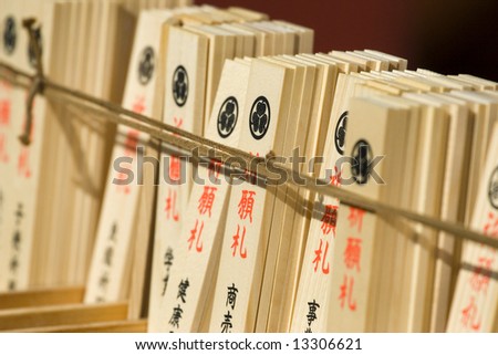A view of written cards tables with good luck desires attached to a rope in a Buddhist temple.