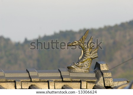 Carp fish statue decorating an oriental roof. Symbol of good luck in japan