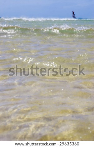 windsurfer surfing the sea. Vertical image. Point of view of a swimmer