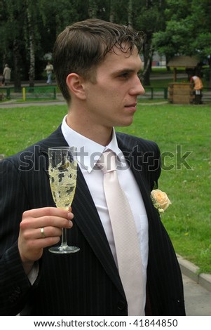 The man in a suit with a champagne glass