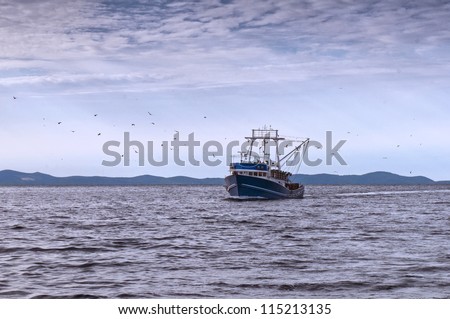 Fishing boat on the sea and sea gulls around