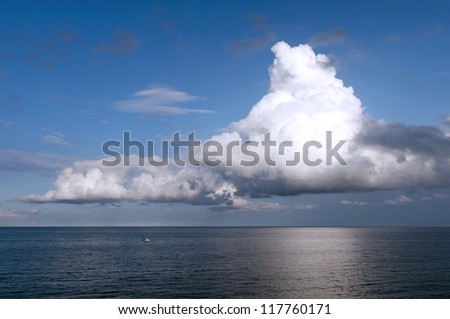 Storm clouds over the sea and a small fishing boat on the sea