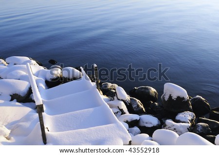 Snow, water, stones and wooden stairs. Sweden