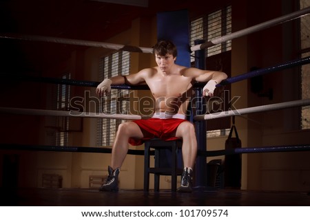 Boxer fighter on the ring resting on ring ropes