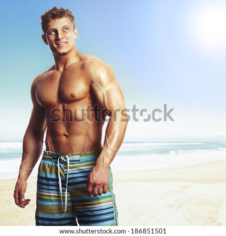 sexy caucasian fitness male model posing on the beach