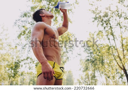 Young exhausted athlete splashing to refresh during a running trail