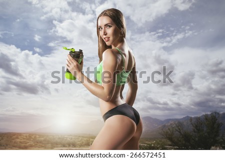 Fitness woman drinking water from bottle. Muscular young female at gym  taking a break from workout. Stock Photo by Satura_