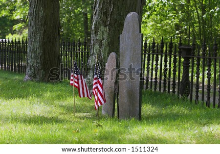 Graves headstone from Revolutionary War decorated with american flags