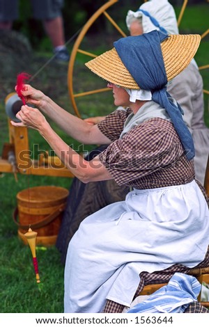 Woman making yarn from a spinning wheel