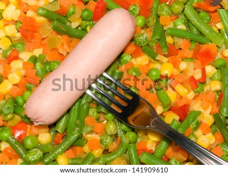 Fried vegetable mix and sausage on fork