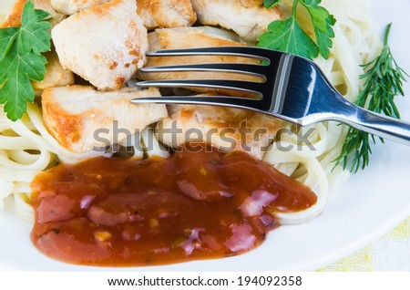 Plate of fried meat, pasta and fork