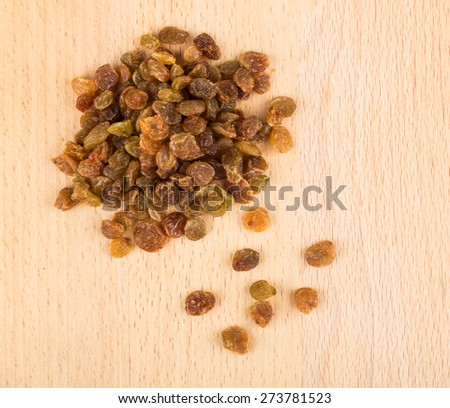 Heap of dried grapes on board made of beech
