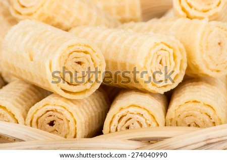 Heap of wafer rolls close up in wicker basket