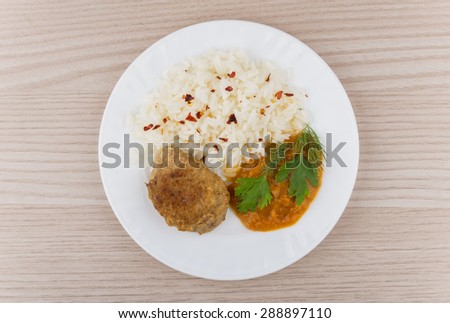 Fried cutlet with rice, squash caviar and greens on table. Top view