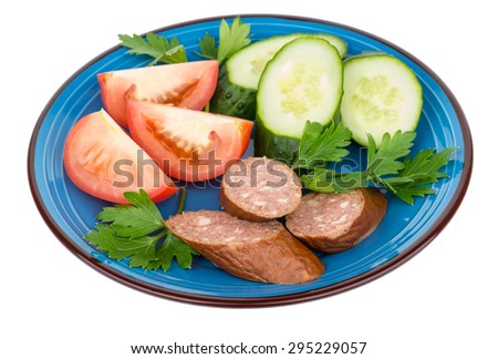 Plate with pieces of sausage, tomatoes, cucumbers and parsley isolated on white background