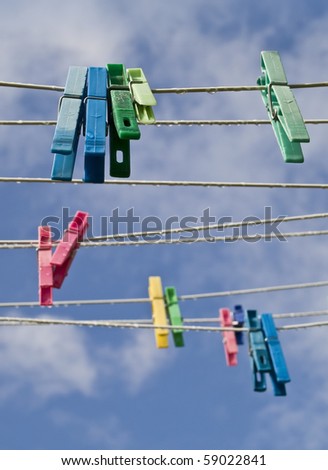Cloth lines with color pegs. Cables and pegs are wet from the summer rain. Focus on the foreground pegs