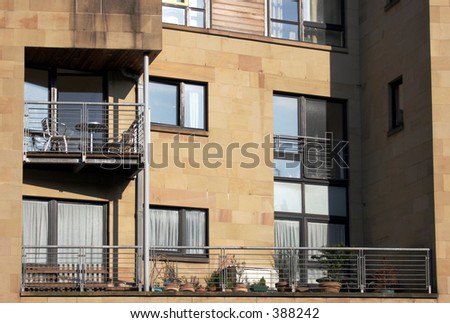 Balconies set into a modern luxury sandstone building