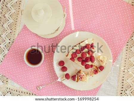 Raspberry cake with cup of tea, lantern and beautiful pink background