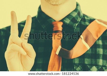 Vintage man with red tie shows victory sign