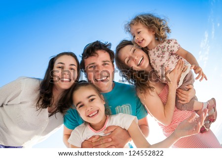 Group Of Happy Smiling People Against Blue Sky